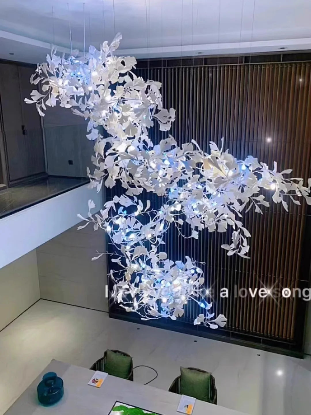 Gingko leaf chandelier hanging above dining table in luxury interior