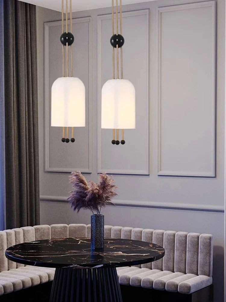 Modern interior design with pendant lights, a round table, and decorative elements.