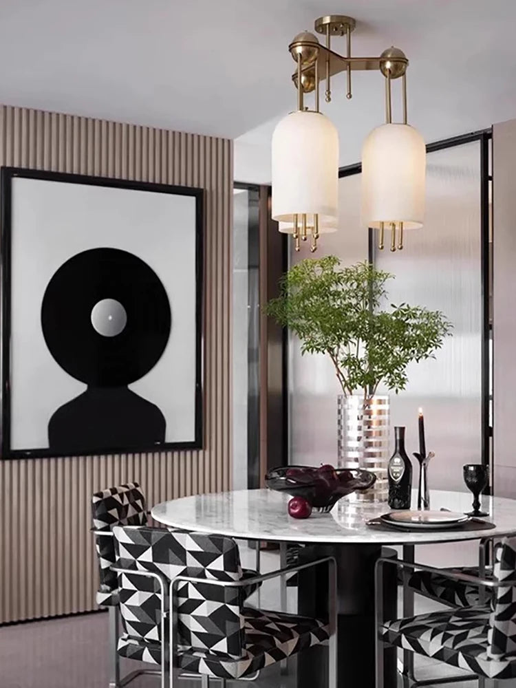 Modern dining room with a round table, geometric chairs, and decorative elements.